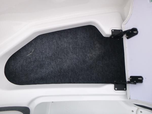 Slide: The Image of 2024 Yamaha AR195 boat interior storage compartment with black carpet lining. - 8