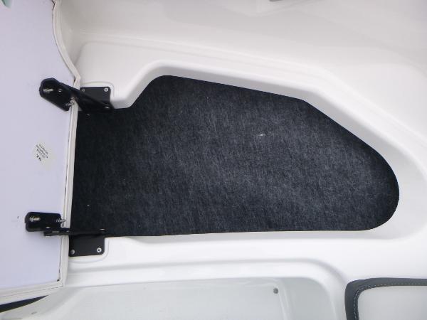 Slide: The Image of 2024 Yamaha AR195 boat interior storage compartment with black carpet lining. - 9