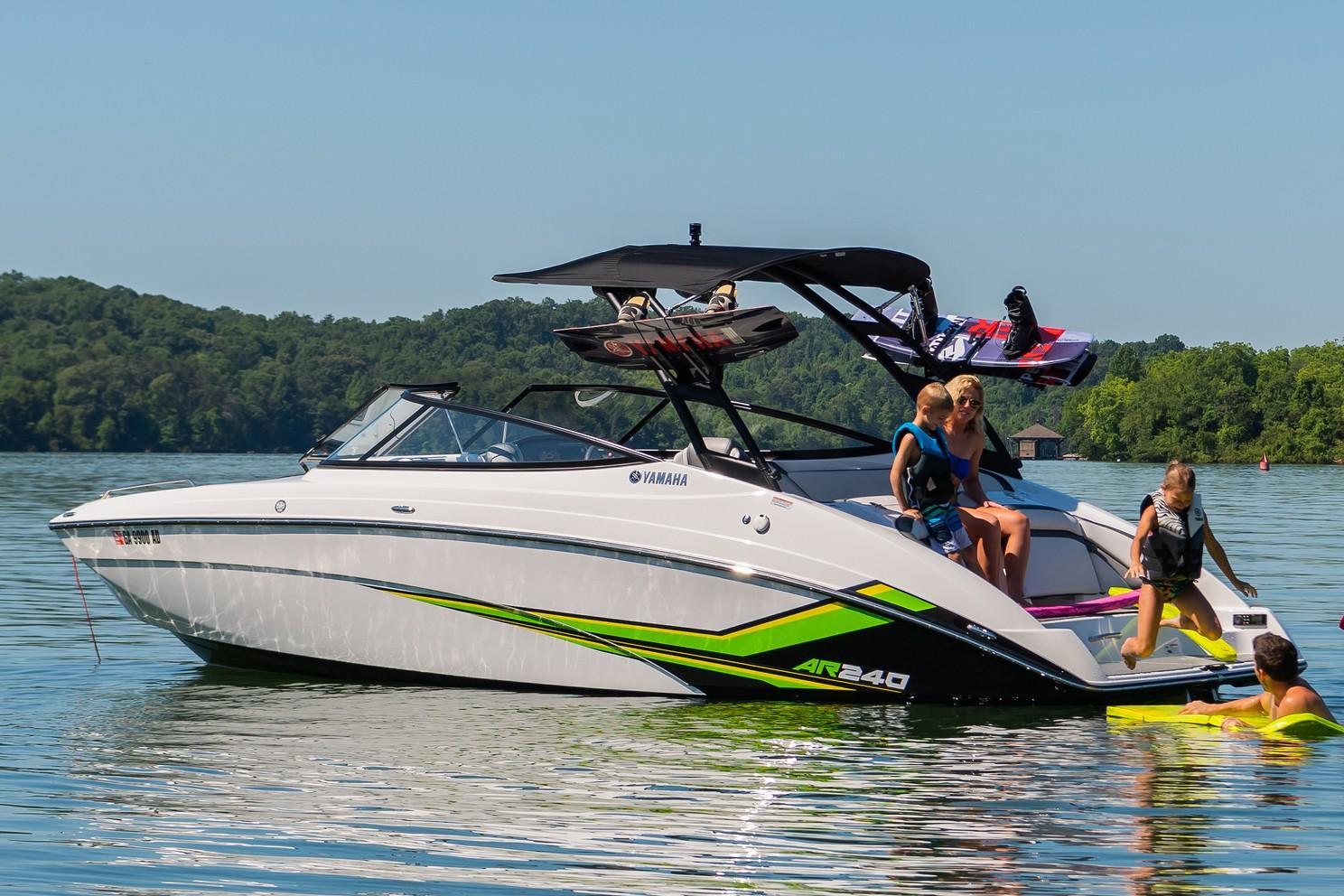 Slide: The Image of 2019 Yamaha AR240 boat on a lake with people enjoying water activities. - 15