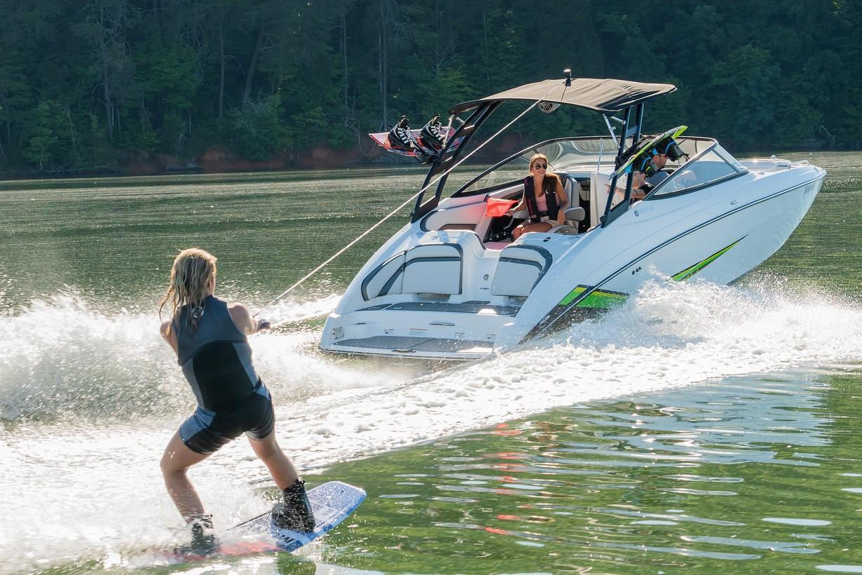 Slide: The Image of Person wakeboarding behind a 2019 Yamaha AR240 boat on a lake. - 17