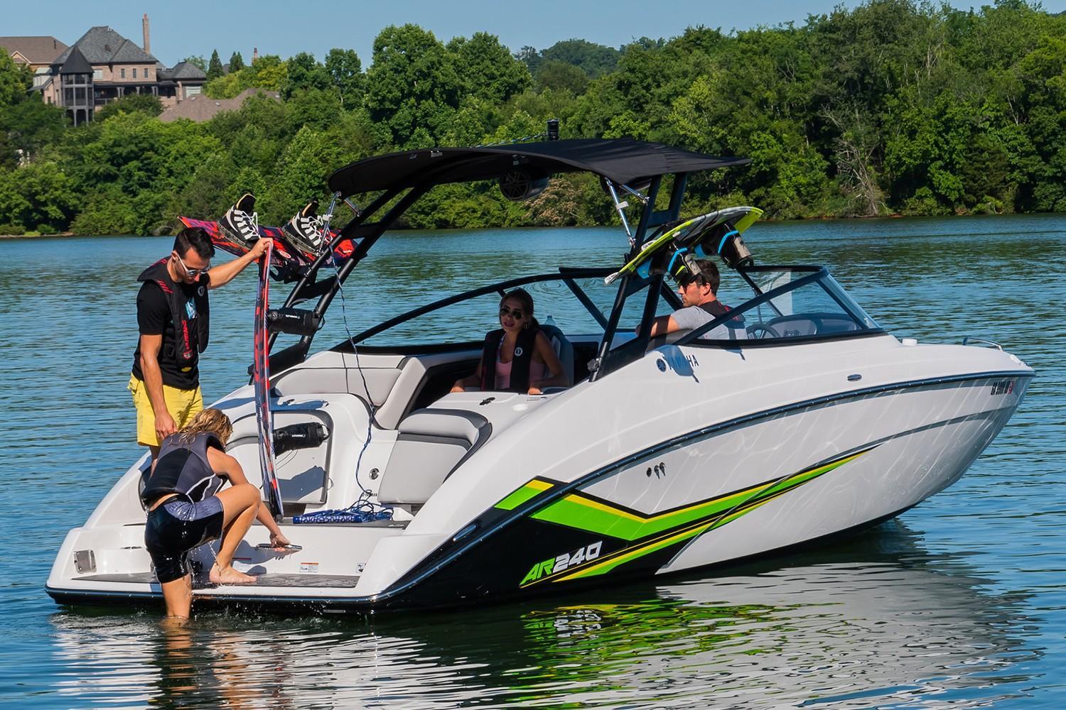 Slide: The Image of 2019 Yamaha AR240 boat on a lake with people enjoying water activities. - 18