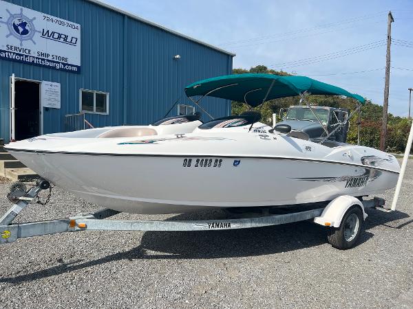Slide: The Image of 2000 Yamaha LS 2000 boat on trailer, parked outside a blue building. - 0