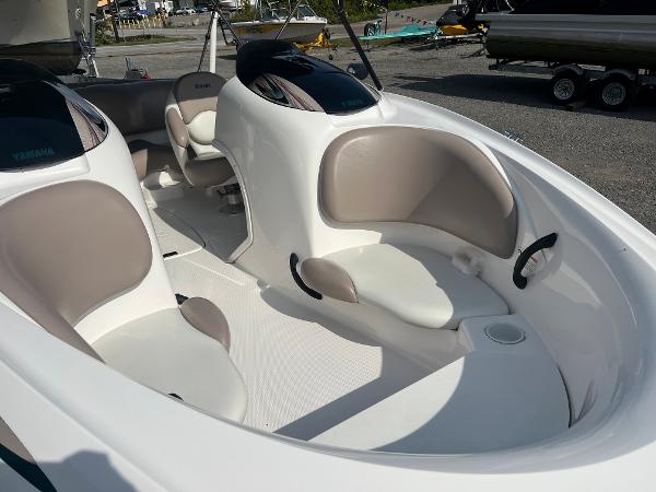 Slide: The Image of 2000 Yamaha Boats LS 2000 interior with white and beige seating, docked outdoors. - 9