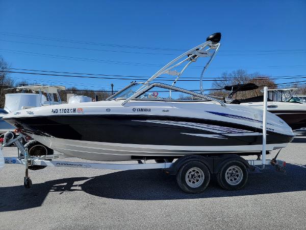 Slide: The Image of 2007 Yamaha SX210 boat on trailer, black and white design, clear blue sky background. - 0