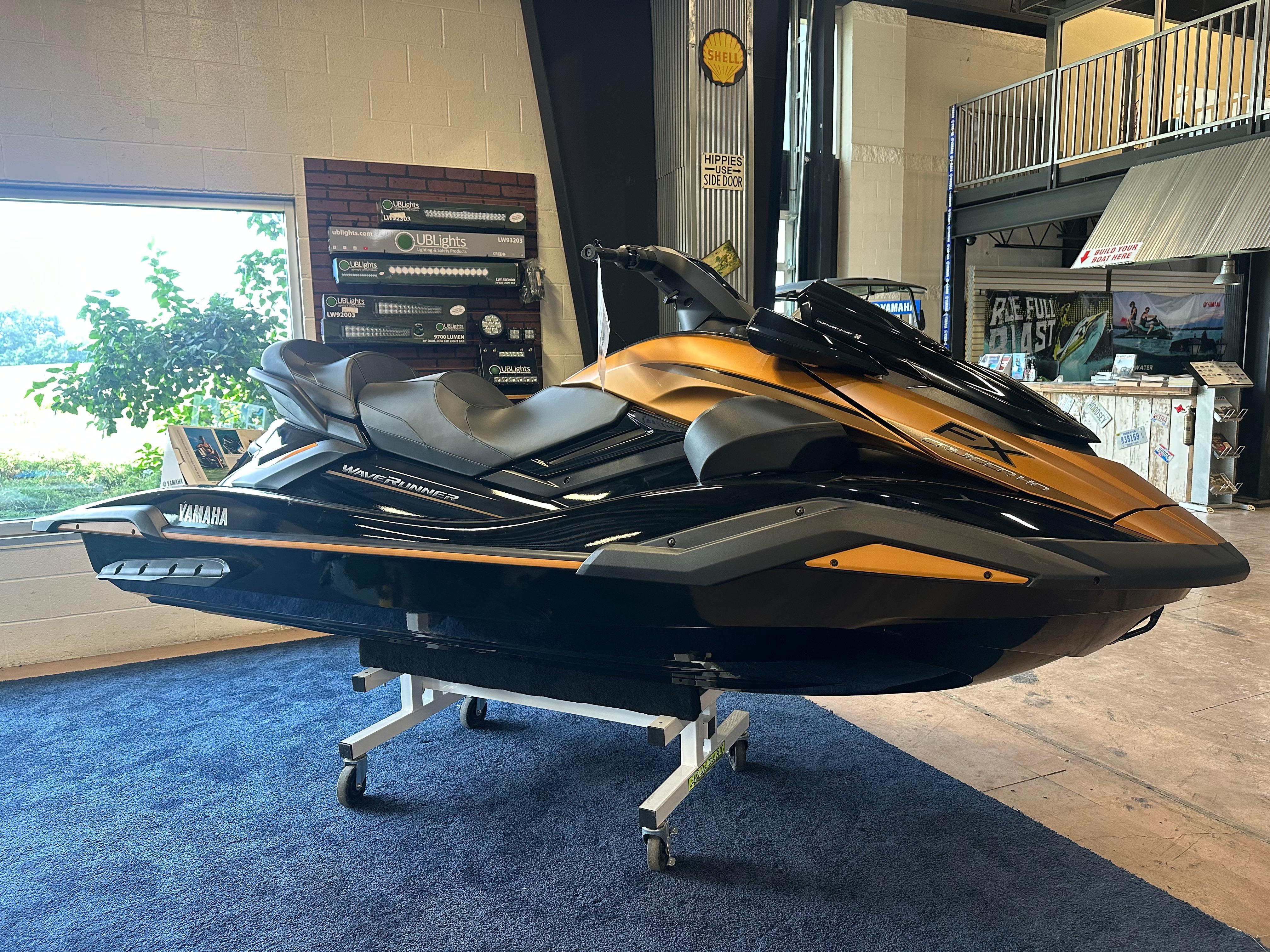 The Image of 2025 Yamaha WaveRunner FX Cruiser HO in showroom, sleek design, gold and black color scheme. - 7
