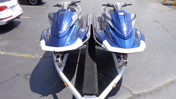 Slide: The Image of Two blue 2015 Yamaha WaveRunner VX Cruisers on a trailer in a parking lot. - 0