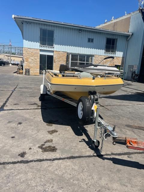 Slide: The Image of 1977 Yarcraft Spirit of 76 boat on trailer, parked outside industrial building. - 2
