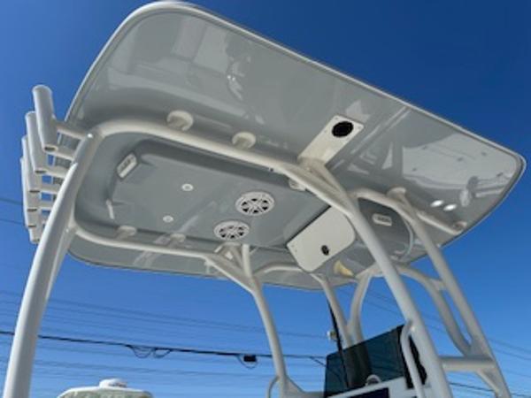 Slide: The Image of 2020 Yellowfin 24 Bay CE boat T-top with speakers against clear blue sky. - 21