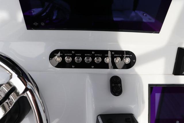 Slide: The Image of Control panel of 2025 Yellowfin 26 Hybrid boat with switches and steering wheel. - 19