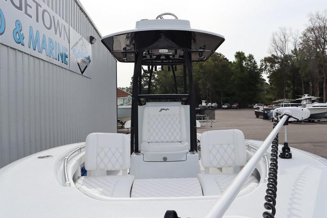 Slide: The Image of 2025 Yellowfin 26 Hybrid boat with white seating, docked near a marine facility. - 7