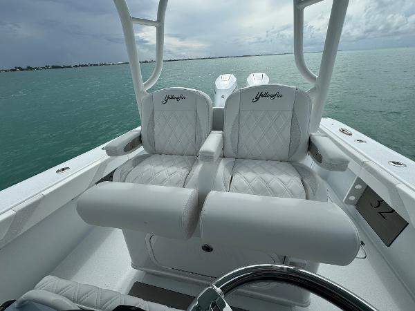 Slide: The Image of 2025 Yellowfin 32 boat interior with white cushioned seats on open water. - 15