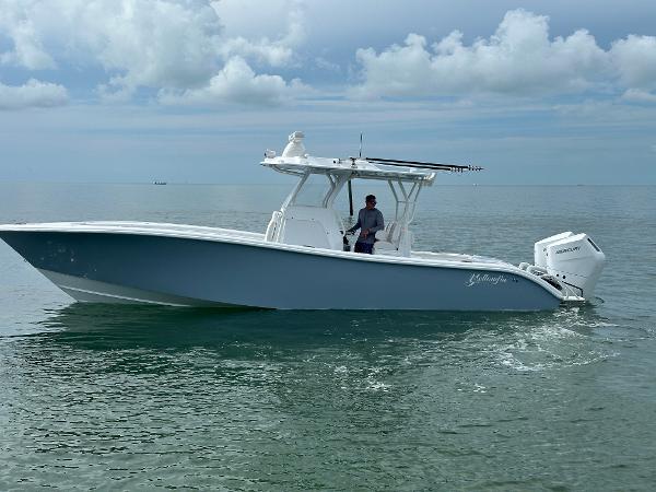 Slide: The Image of 2025 Yellowfin 32 boat cruising on calm ocean waters under cloudy sky. - 2