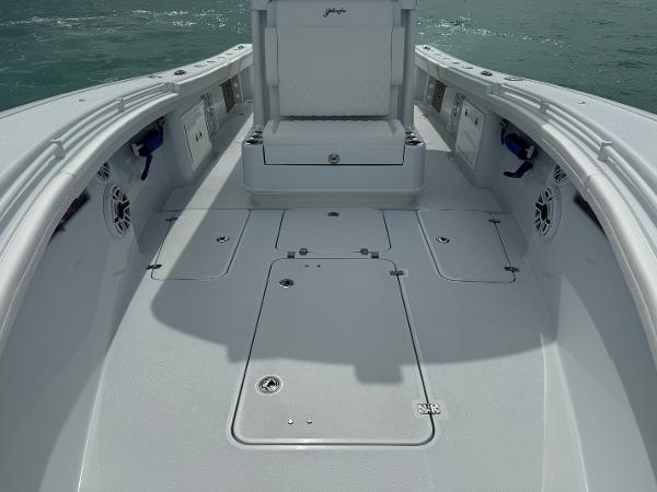 Slide: The Image of 2025 Yellowfin 32 boat deck with storage compartments and seating, on calm water. - 25