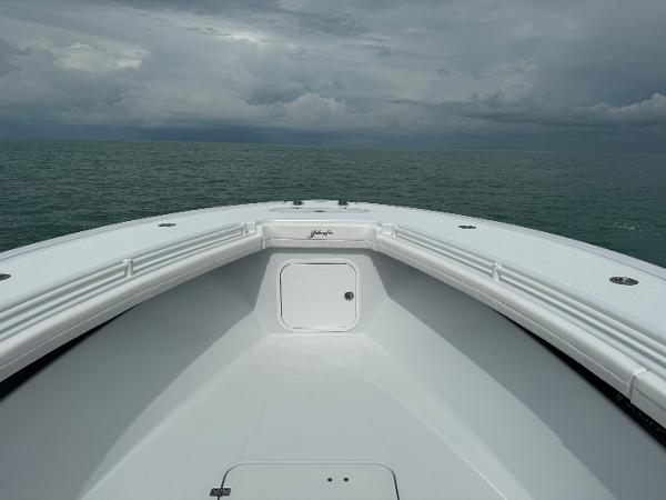 Slide: The Image of Bow view of 2025 Yellowfin 32 boat on open sea under cloudy sky. - 26