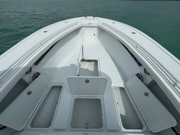 Slide: The Image of 2025 Yellowfin 32 boat with open storage compartments on calm water. - 27