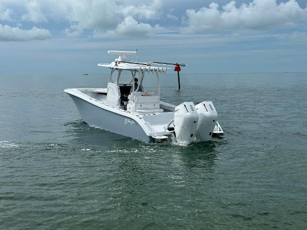 Slide: The Image of 2025 Yellowfin 32 boat cruising on calm ocean waters under cloudy sky. - 7