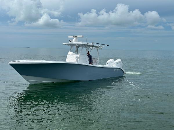 Slide: The Image of 2025 Yellowfin 32 boat cruising on calm ocean waters under cloudy sky. - 9