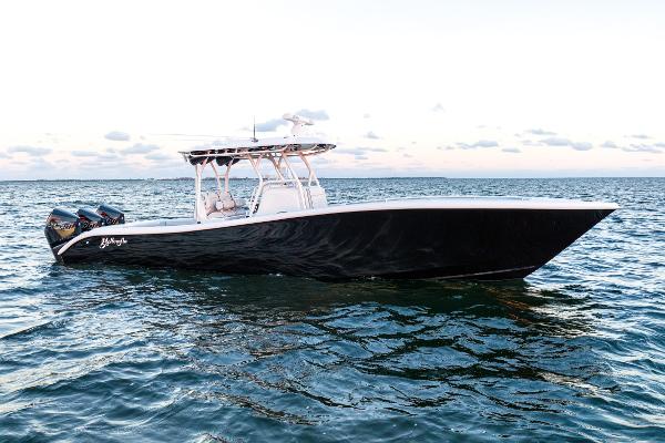 Slide: The Image of 2023 Yellowfin 34 boat on open water, sleek design, triple engines, calm sea. - 0