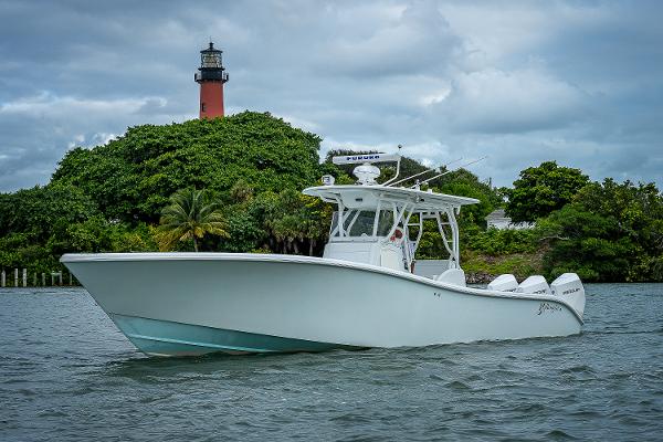 Slide: The Image of 2009 Yellowfin 36 boat cruising near a lighthouse with lush greenery. - 28