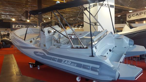 Slide: The Image of 2023 Zar Formenti Zar 65 boat displayed at an indoor boat show. - 6