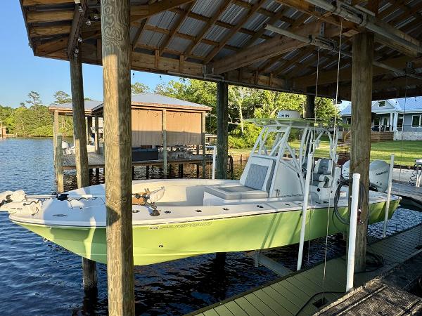 Slide: The Image of 2023 ZCB Freemason 26 boat docked under a wooden shelter by a lake. - 1