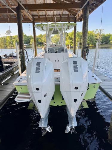 Slide: The Image of 2023 ZCB Freemason 26 boat with dual outboard engines docked on a serene lake. - 2