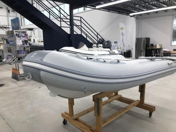 Slide: The Image of 2023 Zodiac Cadet 300 RIB ALU PVC boat displayed indoors on a wooden stand. - 3