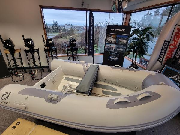 Slide: The Image of 2024 Zodiac Cadet RIB Alu 270 inflatable boat displayed in showroom with outboard motors. - 0