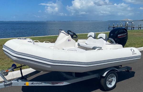 Slide: The Image of 2024 Zodiac Yachtline 360 inflatable boat on trailer by the waterfront. - 0