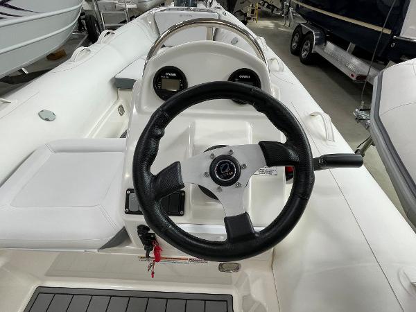 Slide: The Image of 2023 Zodiac Yachtline 490 Deluxe NEO 90hp boat interior with steering wheel and dashboard. - 17